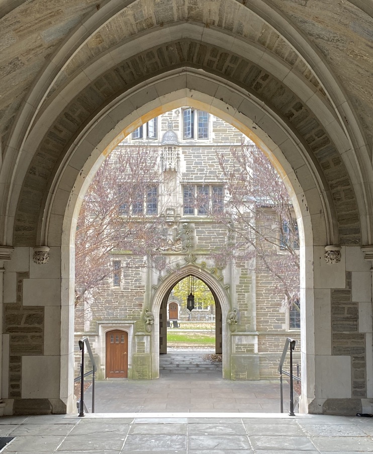 A gothic arch framing a courtyard beyond
